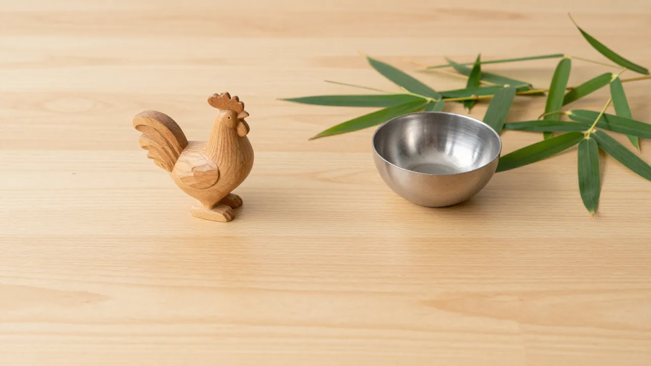 plain wooden rooster figurine, small metal bowl, fresh bamboo leaves